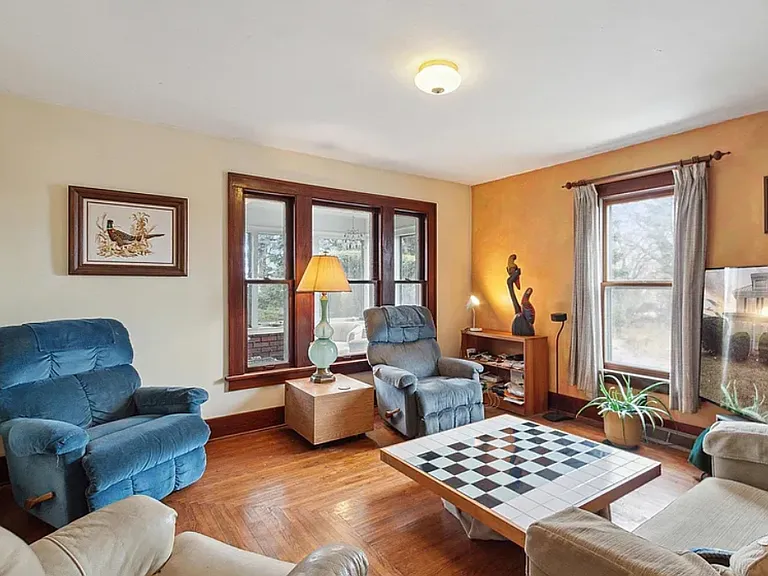 first floor sitting room with loveseat and tables and designer glass lamp
