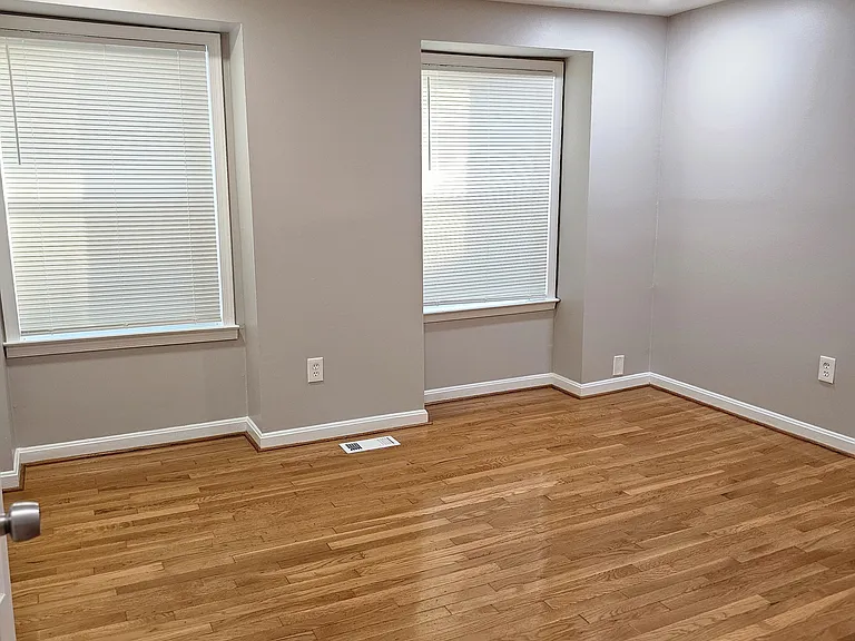 Master bedroom with new hardwood throughout, large spacious closet, and full, extra tall windows facing front yard and plenty of maple and oak trees.