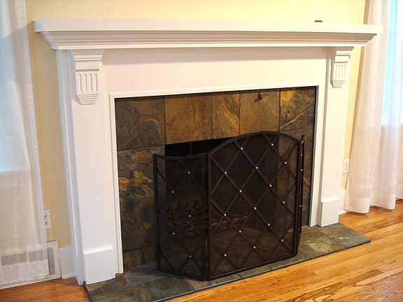 Fireplace with enameled wood mantel & natural slate surround.