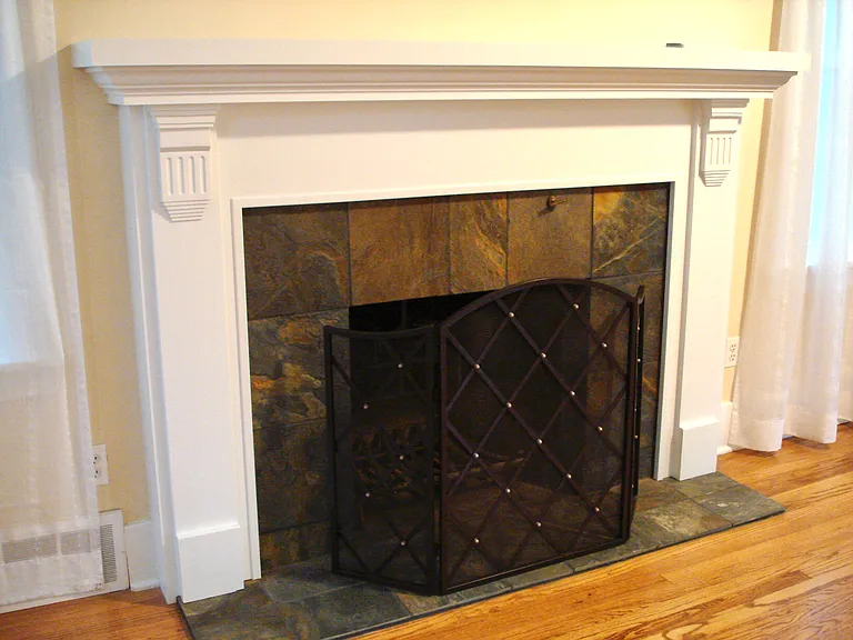Fireplace with enameled wood mantel & natural slate surround.