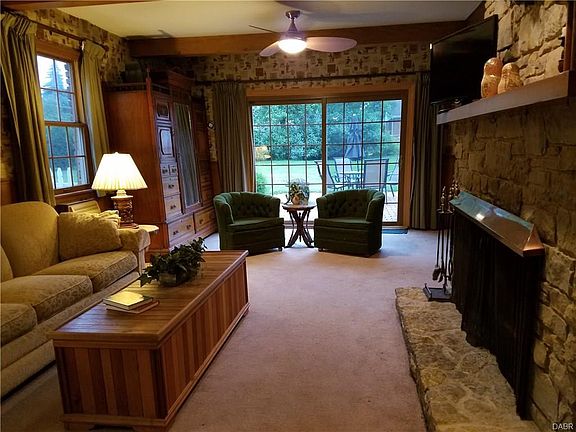 FAMILY ROOM WITH WOOD BURNING GAS STARTER FIREPLACE AND PATIO DOORS LEADING TO THE BRICK PATIO
