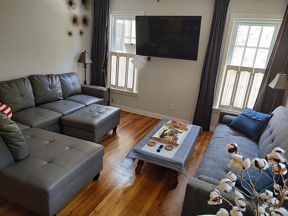Living room with sectional, and fold down futon couch. The futon can be made up as a double sized bed.