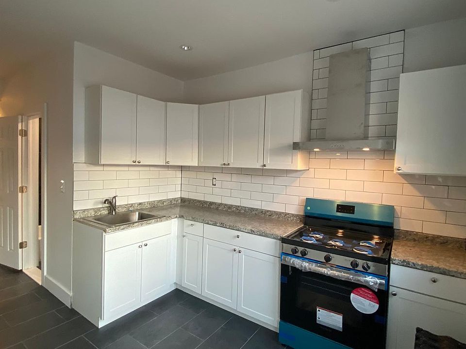 This photo is the kitchen looking to the living room and exit to the street