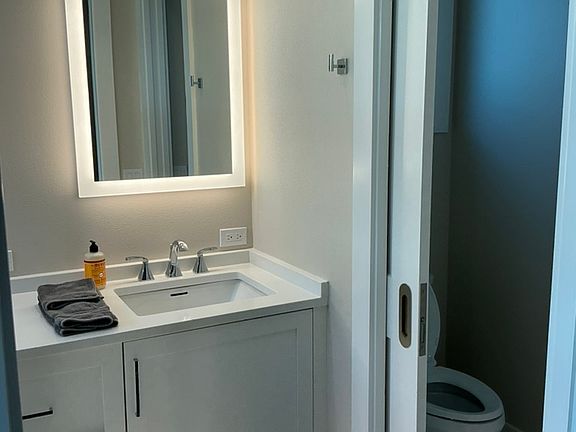 Double sinks and privacy en suite bath in primary bedroom