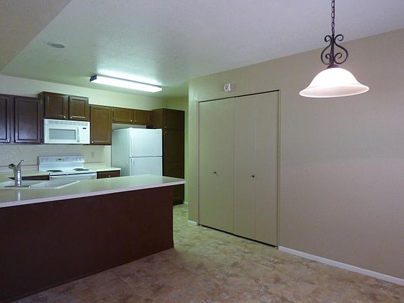 Kitchen with full size washer and dryer behind laundry closet doors.