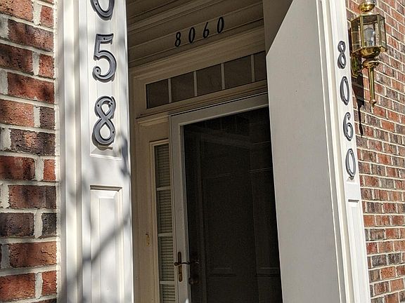 Front door, with an Anderson Renewal storm door, surrounded by windows on two sides.
