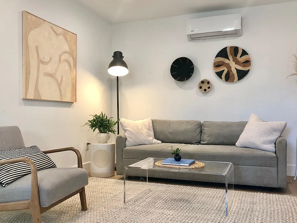 Clean and cozy living space with smart TV, opens to the kitchen.