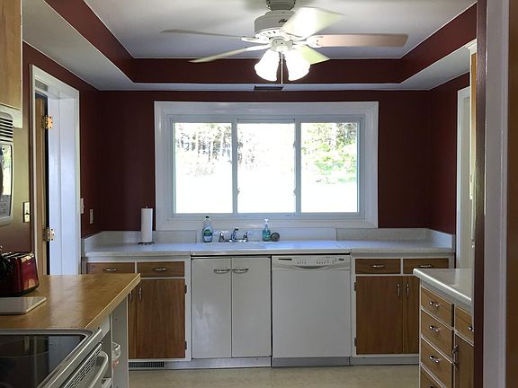 Kitchen with large window view of 70 year old pine forest. Kitchen is fully stocked with pots/pans, dishes, silverware.