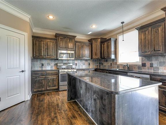 Kitchen features an abundance of cabinets and center island/bar