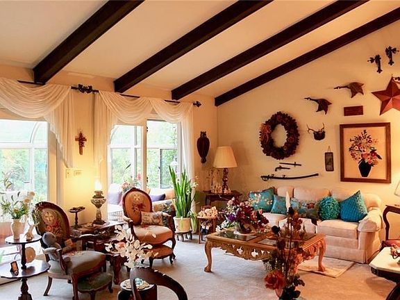 Sunken Living Room with wood bean ceiling, custom window treatment, new gray wall to wall carpet