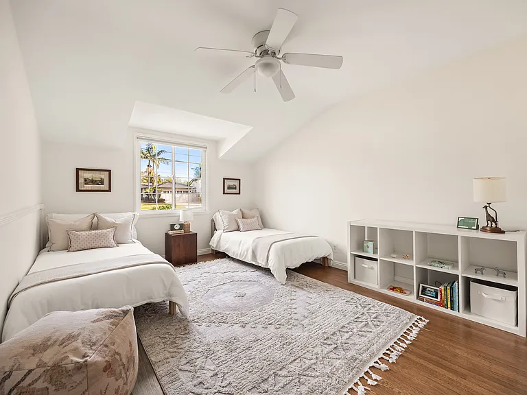 Third bedroom with two twin beds, built-in storage, and closet space, with a crib available upon request.