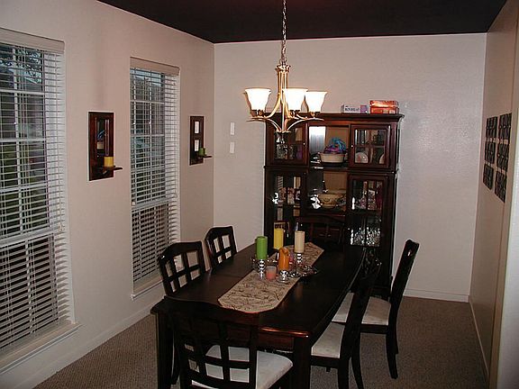 The dining room off of the entry shows off it's windows and their natural light, gorgeous chandelier and walkway directly into the kitchen.