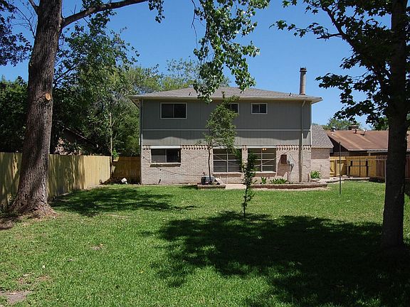 Back yard with recently replaced fence.  Nice size patio and trees.