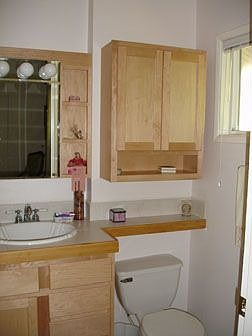 Newly tiled mstr bath with new maple cabinets and sink; has shower stall to left of cabinet.