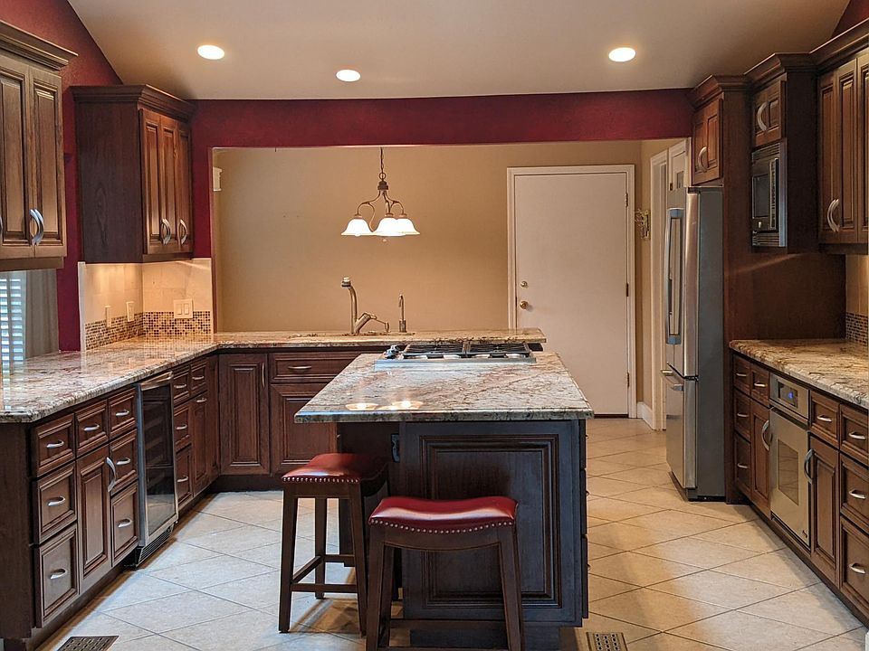 Gourmet kitchen with granite counters, wood cabinets, island, top kitchen appliances