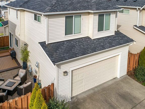 Attached two car garage with trex deck & tile patio on the side of the home. 