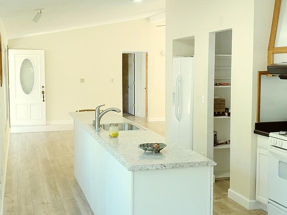 Kitchen With Island & Pantry Area Right Of The Stove.