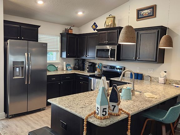 Granite countertops, recessed lighting and coastal pendant lighting