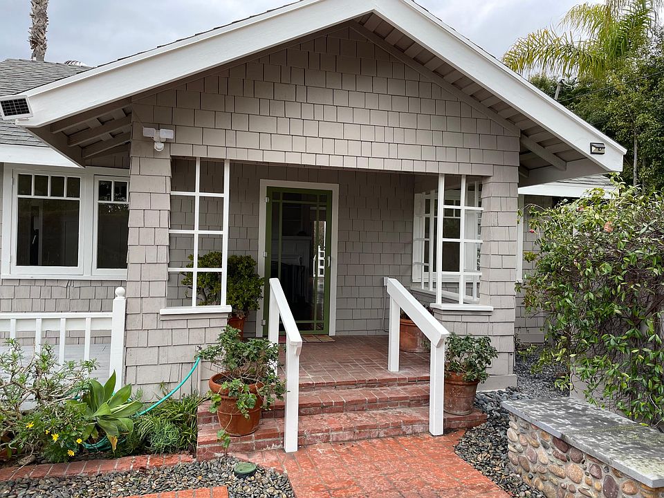 front door located in front courtyard with deck and brick patio