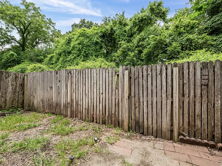 fenced in back patio and yard area that backs to trees