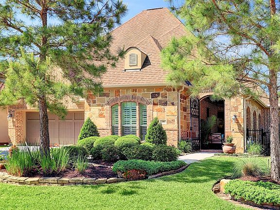 This luxury patio home built by Darling Homes has a lovely enclosed front porch entrance to greet your guests as they enter the home. Notice the tasteful combination of brick and stone on the exterior.