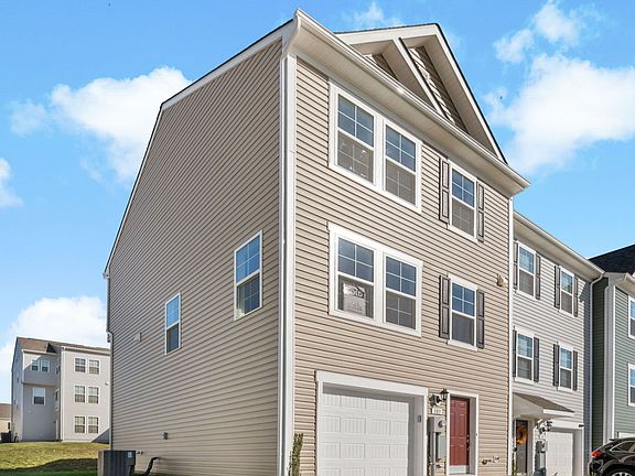 Side exterior view of the York II Townhome floor plan at Homestead Acres by DRB Homes, located in Ha