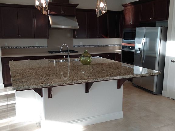 Large kitchen with large refrigerator, huge island counter.