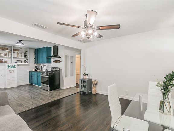 Living room featuring dark wood-style floors and ceiling fan