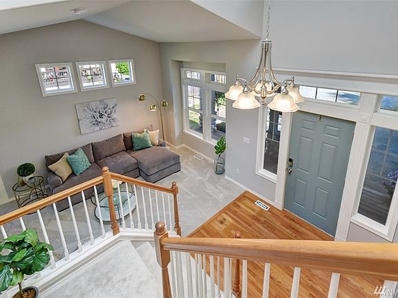 Looking down into entry and living area from top of the grand staircase.  Large skylight in the vaulted entry ceiling. All windows and skylights throughout the home professionally cleaned.