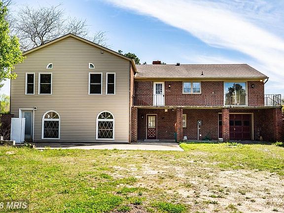 Back of home with porch and drive under garage