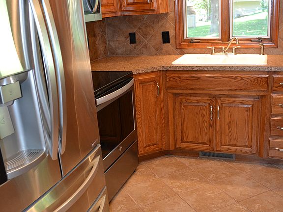 Updated kitchen with stainless-steel appliances and oak cabinetry.