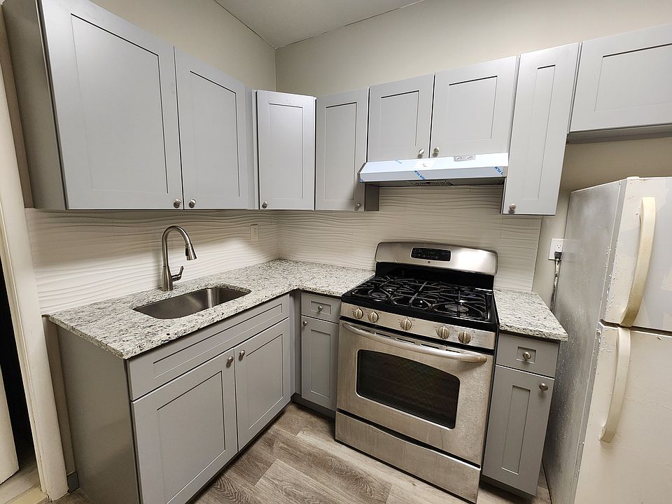 Stainless Steel Range + White Refrigerator. Grey cabinets.