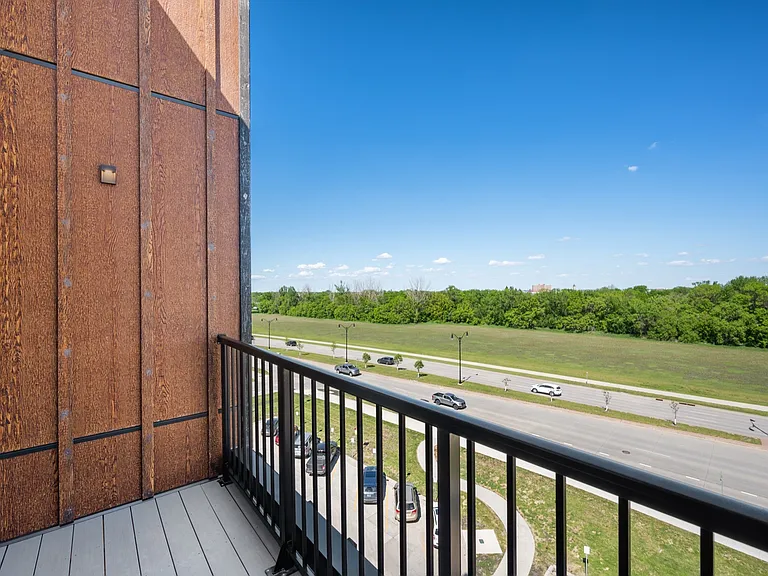 Charming balcony view showcasing lush green surroundings and a peaceful road, perfect for relaxation. Charming balcony view showcasing lush green surroundings and a peaceful road, perfect for relaxation.