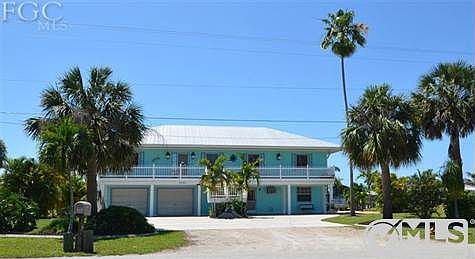 Street View - metal roof, double car garage plus storage with mature landscaping