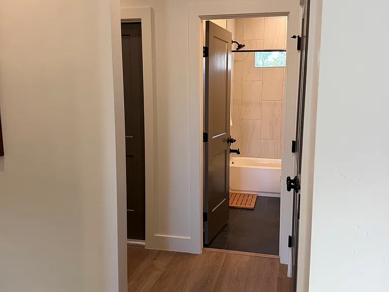 Main level hallway and full bathroom that is next to great room