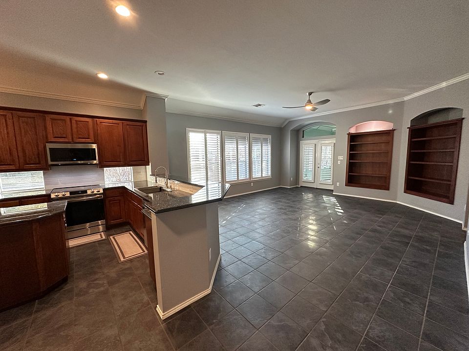 Spacious kitchen with island that opens to a dining area with beautiful built in shelves and lots of natural light.