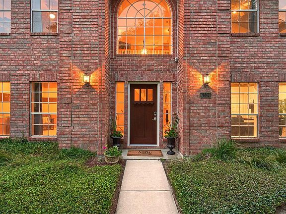 Vibrant green landscaping accents the brick exterior and welcomes guests.
