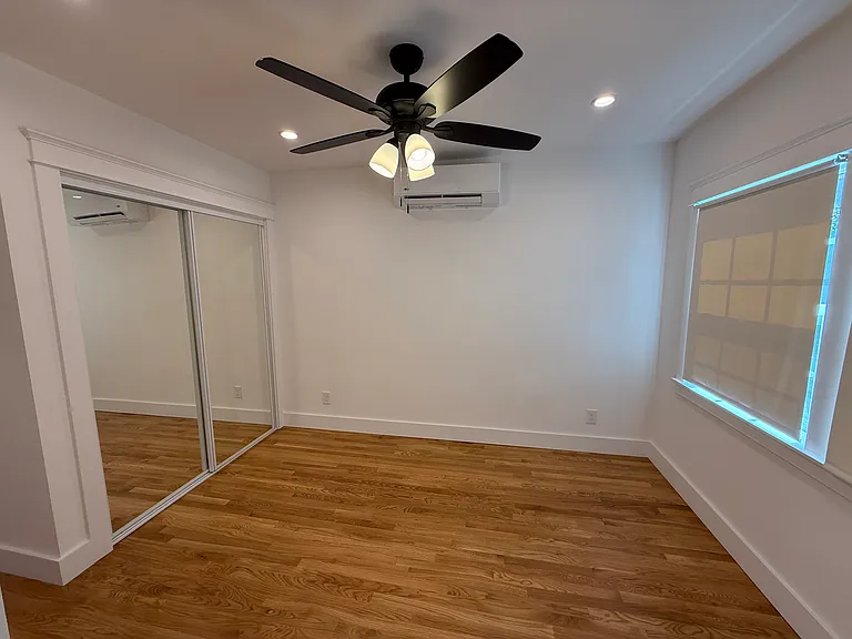 MASTER BEDROOM WITH HUGE MIRRORED SLIDING GLASS DOORS, CEILING FAN AND SEPARATE ZONE MINI-SPLIT A/C AND HEATING
