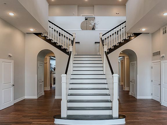 Step into luxury with this elegant foyer, highlighted by a stunning staircase design.