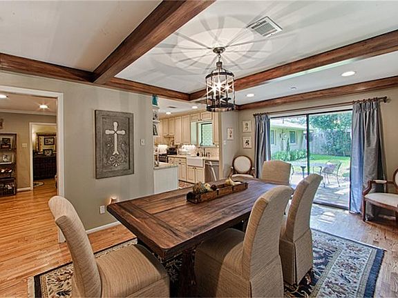 Dining room with hand stained beams, original hardwoods, recessed lighting and looks out to the back