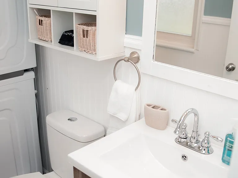 Bright vanity area with a wood-toned cabinet and extra storage for your toiletries.