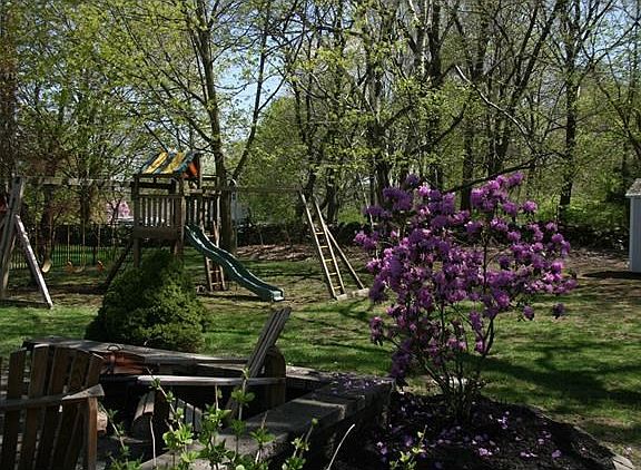 Rear view from patio of shed and play equipment.