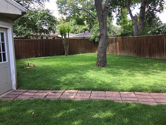 Large sprinklered back yard with brick walkway to garage and Stain Cedar fence enclosure. Large Pecan tree.