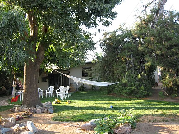 Back yard and house with lots of large shade trees.