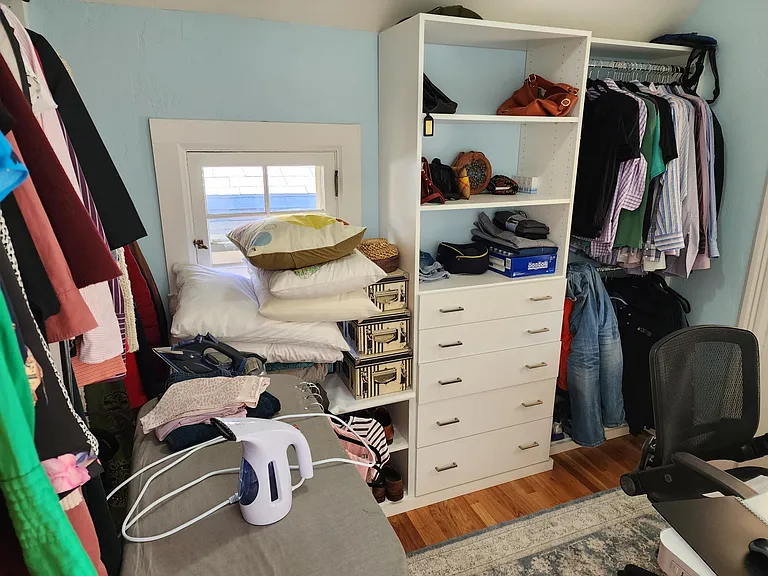 Huge walk in closet with new shelving. Large enough even for an ironing board and desk!