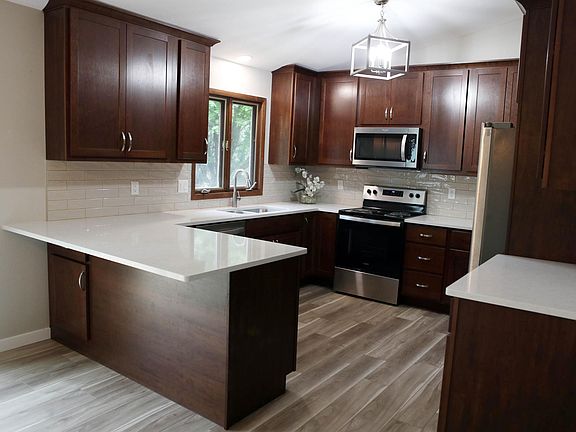 All-new cabinets, quartz countertops, and LVP flooring in the spacious kitchen with eat-in counter space