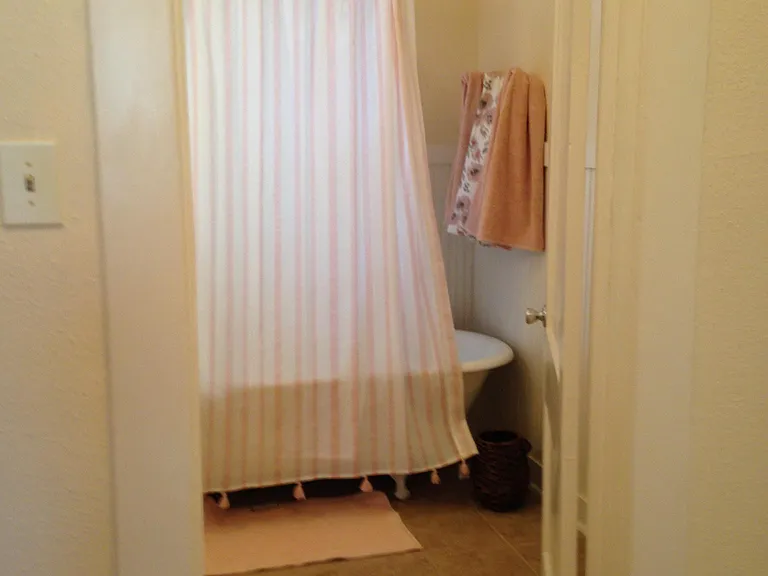 Original large claw foot tub with modern shower over tub. Large bath offers new plumbing and newer porcelain fixtures such as toilet and sink. Porcelain tile flooring in neutral light and airy color selection.