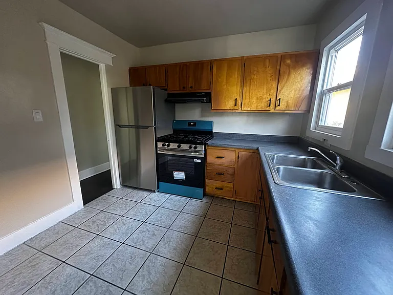 Beutiful kitchen with lots of wood cabinets for storage and cooking.