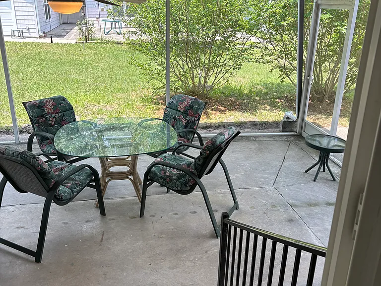 Screened in porch with table and chairs included and side patio for outdoor grilling