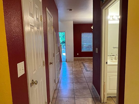 Cute hallway passing living room, storage room, pantry area and bathroom